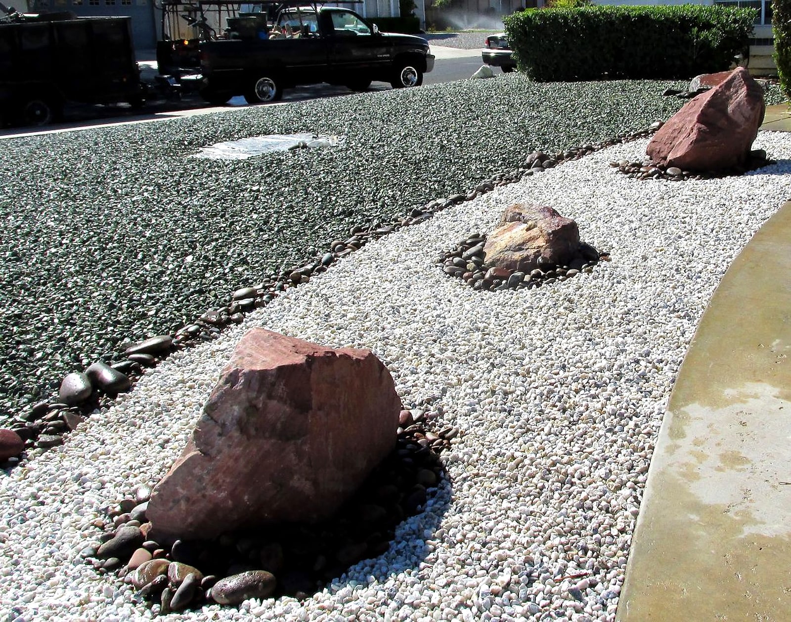 Bands of grey and white gravel with red boulders set in cobble rings