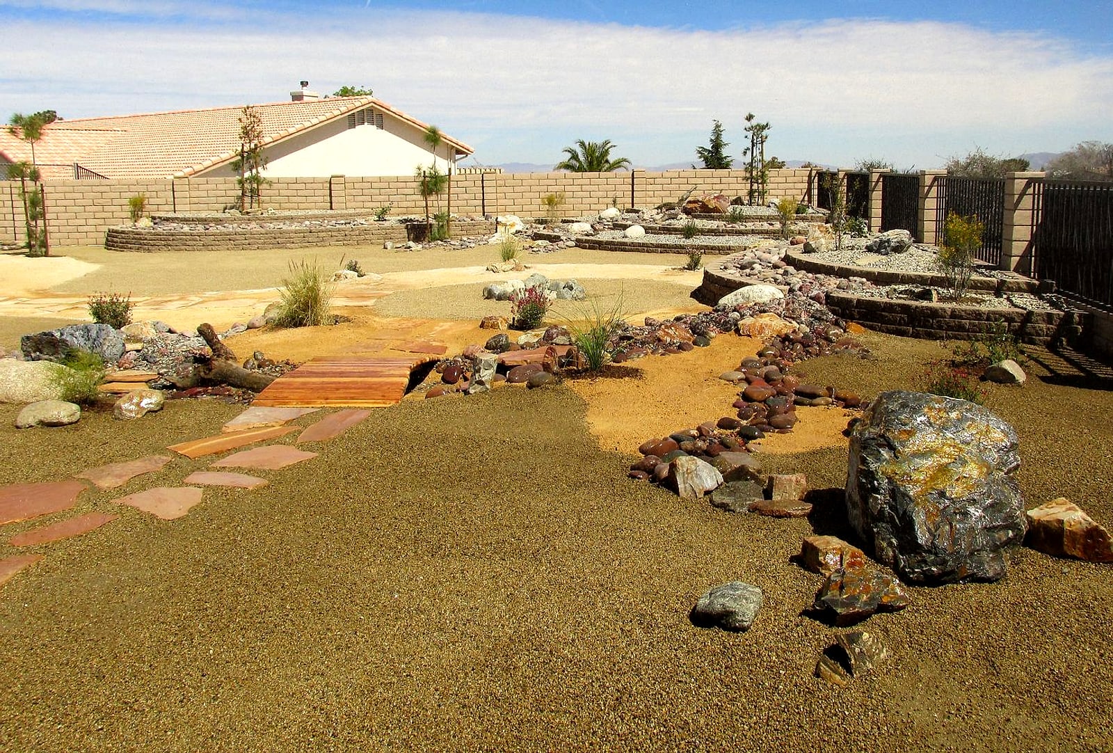Large graded backyard with decomposed granite, flagstone path and boulders