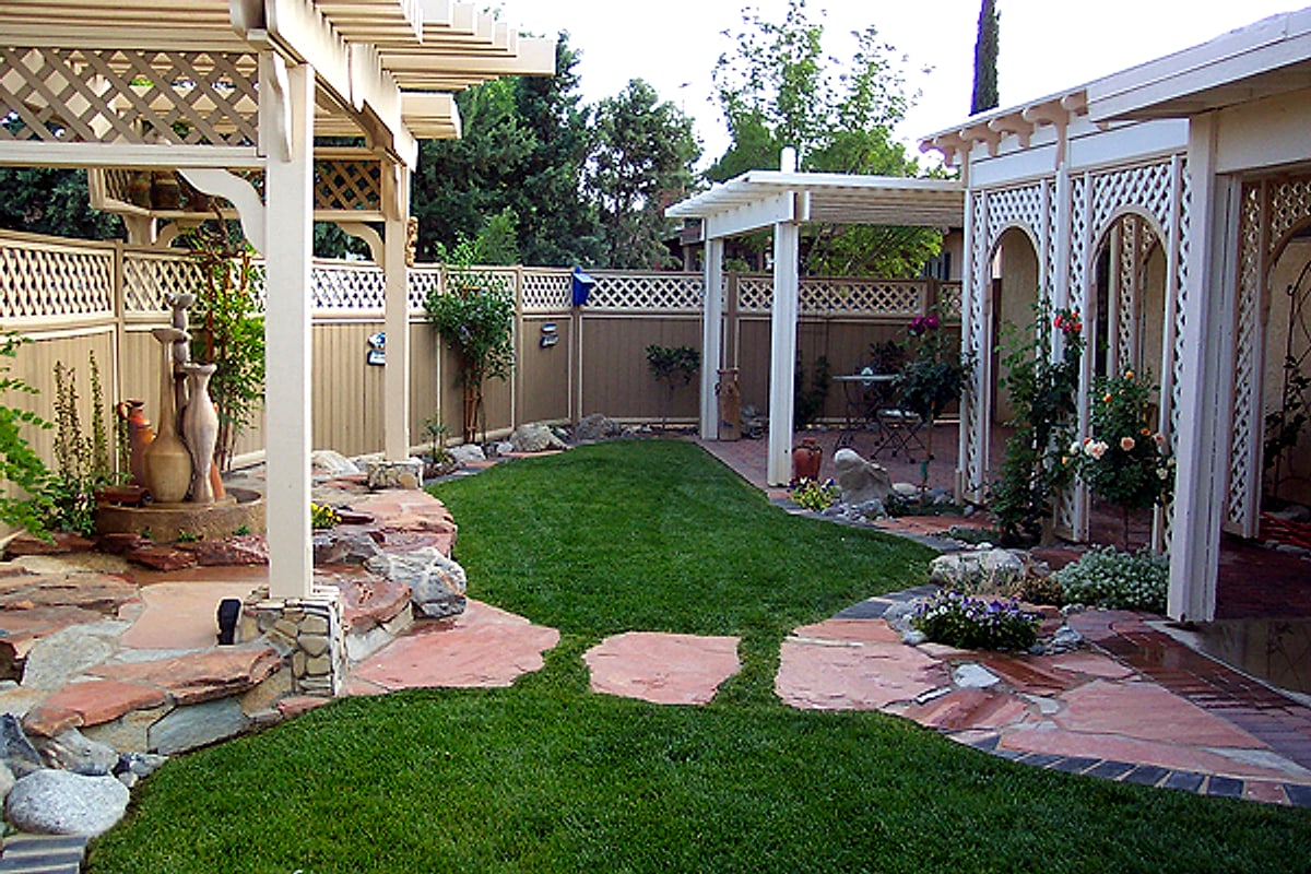 Backyard lawn with flagstone stepping stones and a lattice patio