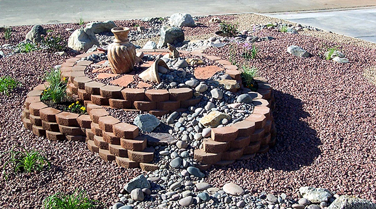 Block planter with a dry creek and a clay pot in red rock